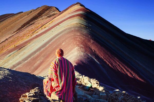 hombre contemplando la montaña de colores vinicunca en peru